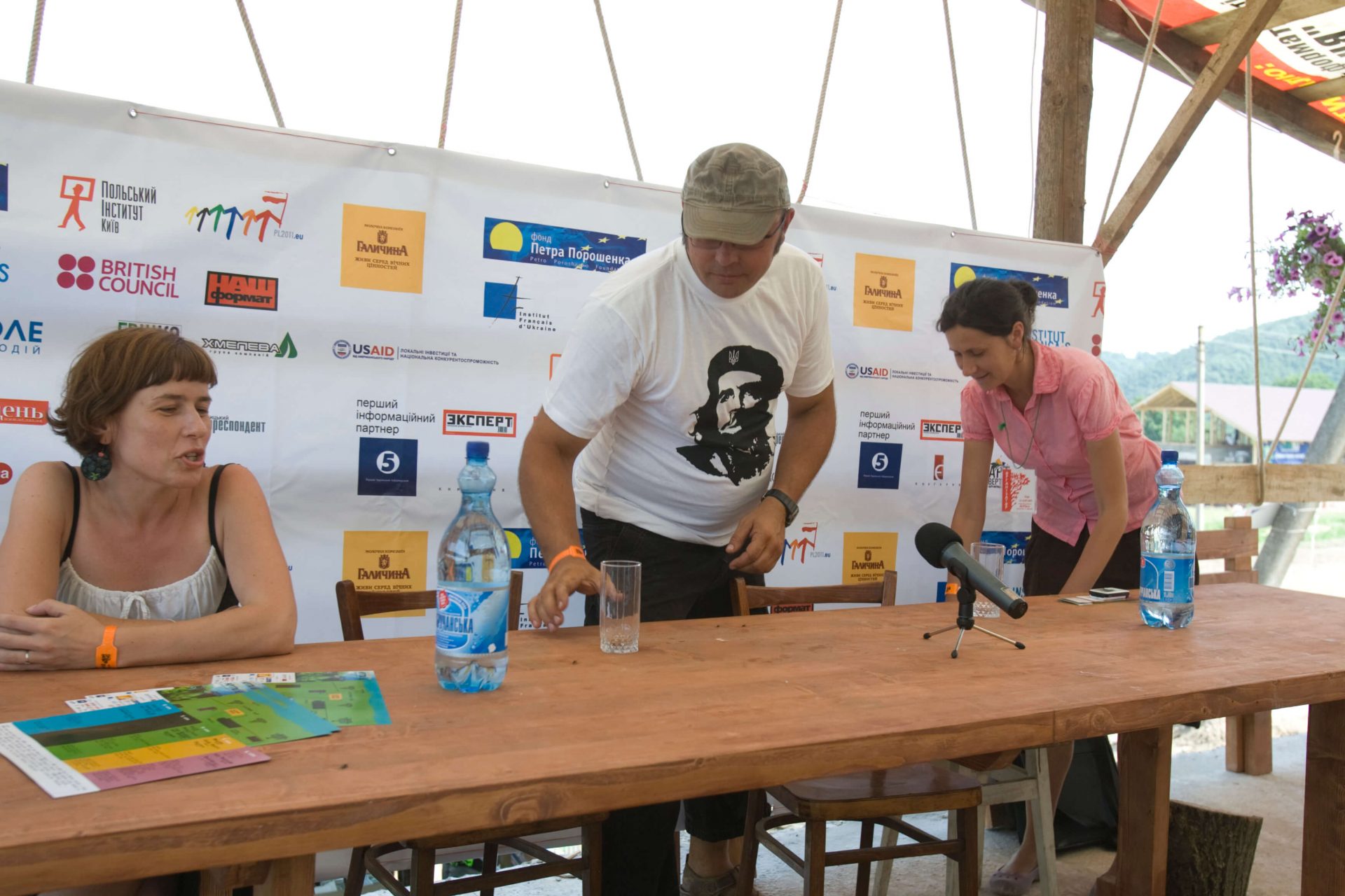 Оля Михайлюк та ще двоє організаторів заходу за столом на фоні банера на фестивалі в Унежі