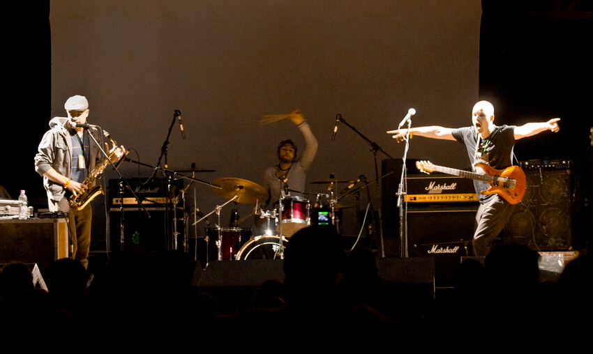 Саксофоніст, барабанщик та гітарист виступають на сцені фестивалю в Унежі