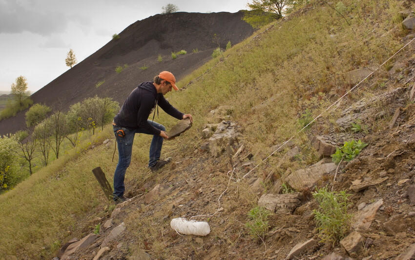 Олег Божко викладає кам'яне коло на схилі гори на фестивалі ARTPOLE.LU